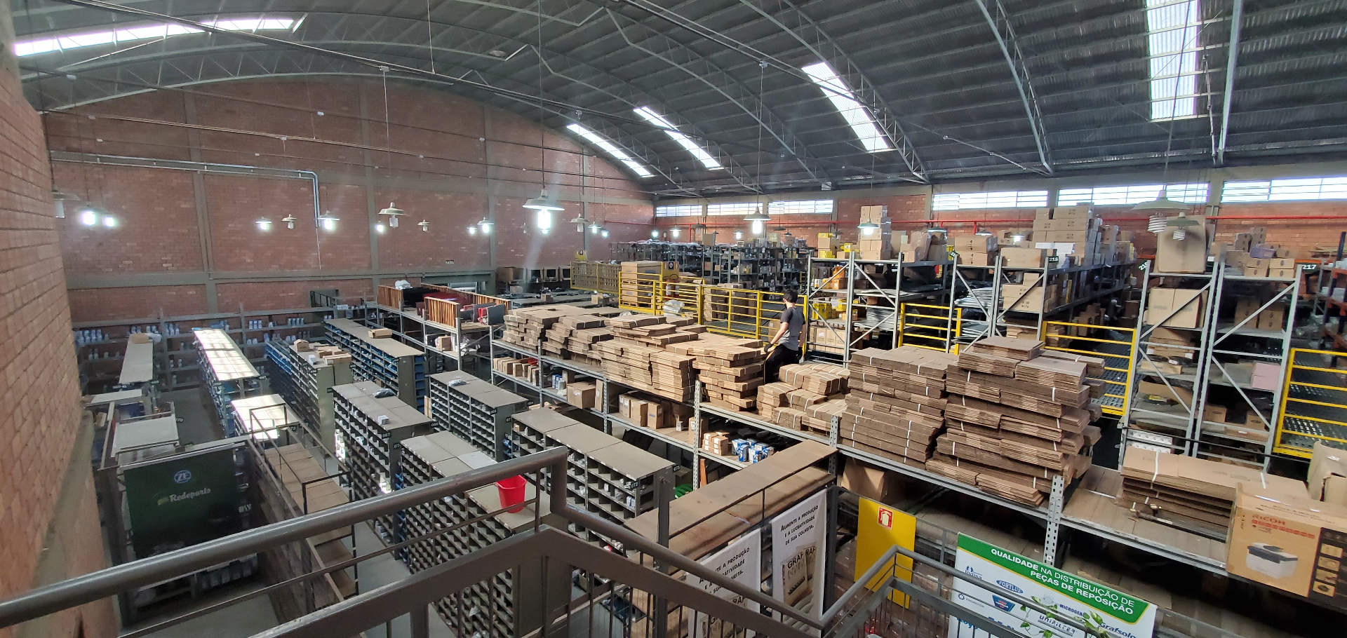 Interior do galpão Redeparts Canoas visto do mezanino, com estoque organizado por marca